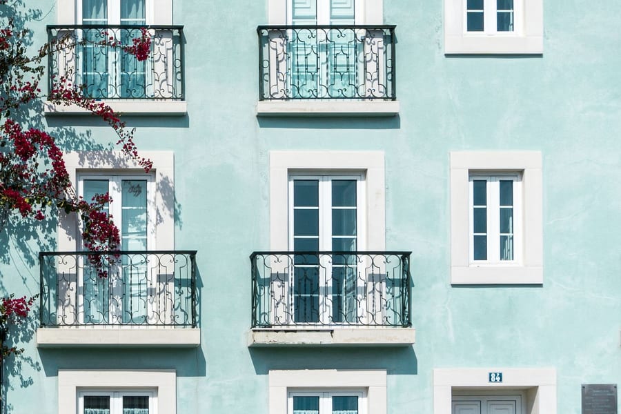 Fachada de um prédio residencial com varandas de ferro e janelas brancas